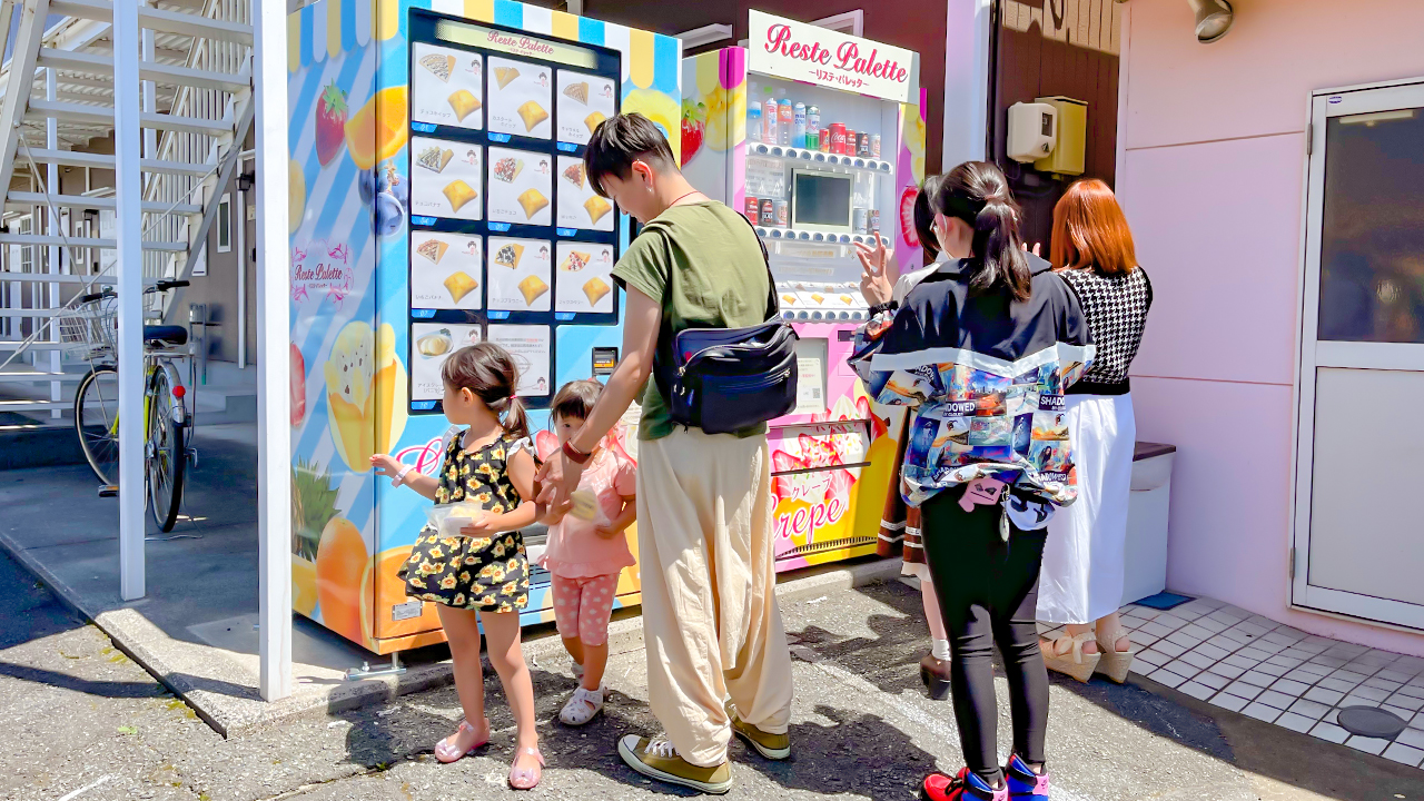自販機に並ぶお客さん　大人も子供も男女関係なくクレープを楽しんでいるよう
